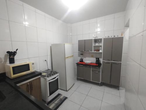 une cuisine avec des appareils en acier inoxydable et un micro-ondes dans l'établissement Casa na praia férias, à Vila Balneária