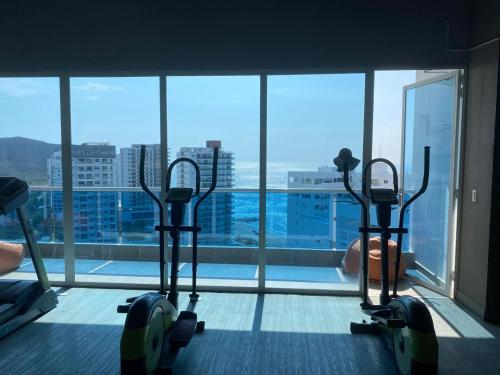a gym with three treadmills in front of a window at Condominio Reserva del mar Santa Marta in Gaira