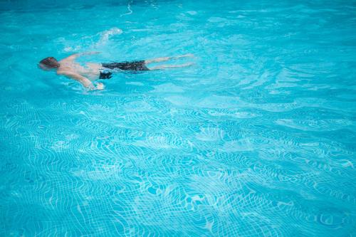 a man is swimming in a swimming pool at Résidence Les Calanques in Ajaccio