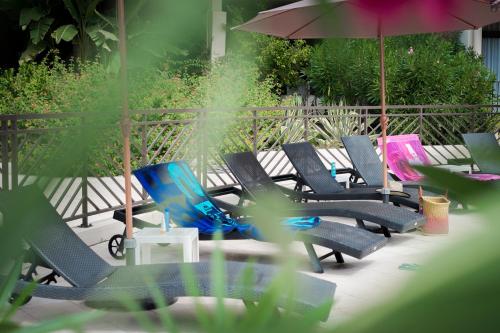 a group of chairs and an umbrella on a patio at Résidence Les Calanques in Ajaccio