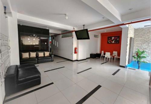 a living room with a black leather chair and a tv at Departamento en Exclusiva Zona in Chiclayo