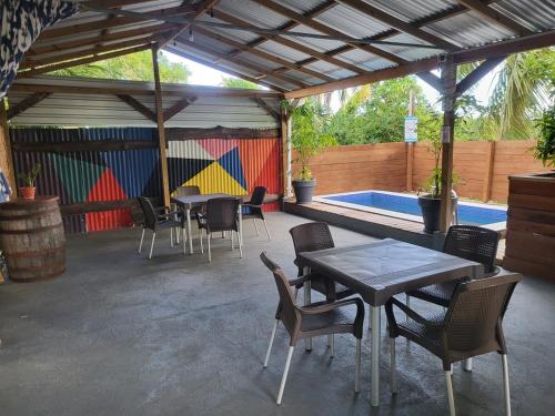 a patio with tables and chairs and a swimming pool at The Local Experience - Kalbas Suite in Choiseul