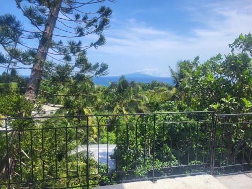 a view from a garden through a metal fence at The Local Experience -Kosol Suite in Choiseul