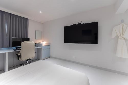 a white room with a desk and a chair at Aank Ryokan x Aank Air Cheongju in Cheongju