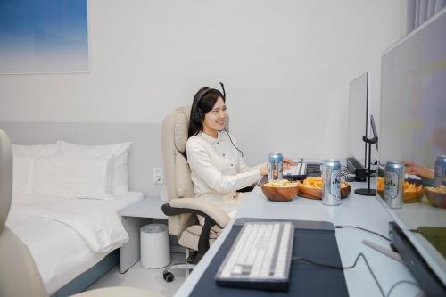 a woman sitting at a desk in an office at Aank Ryokan x Aank Air Cheongju in Cheongju