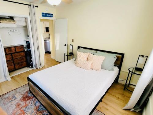 a bedroom with a bed with white sheets and pillows at Beach Bungalow By The Sea 1 in Cocoa Beach