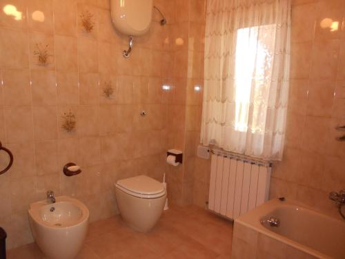 a bathroom with a toilet and a sink and a tub at B&B Andalas in Olbia