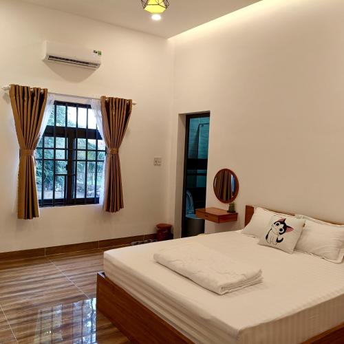 a bedroom with a bed and a window at KHÁCH SẠN ĐỨC CHÍNH 2 - Phan Rang in Bắc Sớn