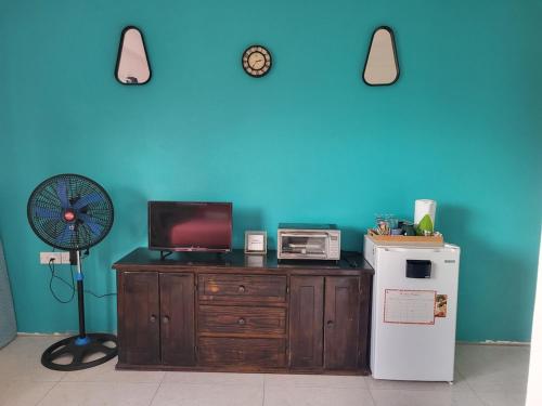 a room with a refrigerator and a blue wall at The Local Experience -Kosol Suite in Choiseul