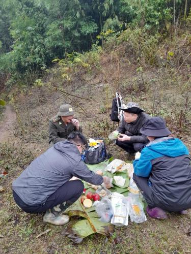 a group of people sitting on a hill eating food at Khách sạn Vườn Quốc gia Ba Bể in Bak Kan
