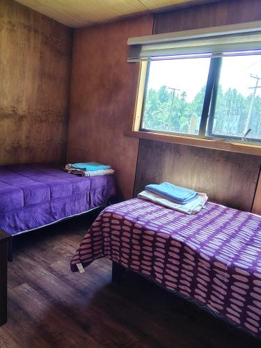 a room with two beds and a window at Cabaña Valdivia Piedra Blanca 2 in Valdivia
