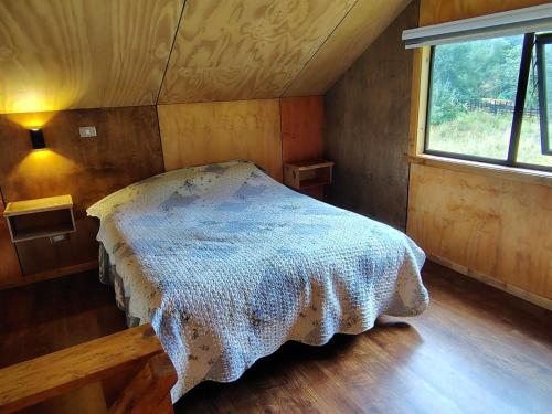 a bedroom with a bed in a room with a window at Cabaña Valdivia Piedra Blanca 2 in Valdivia