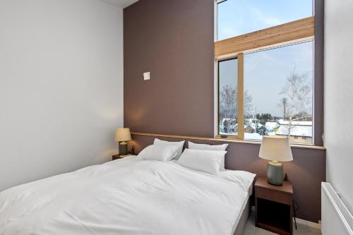 a bedroom with a white bed and a window at Aoyama Lodge 2 in Kutchan
