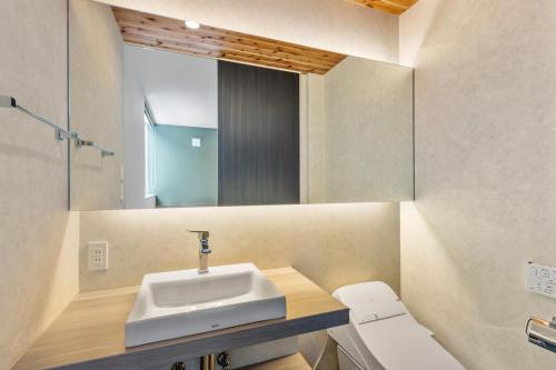 a bathroom with a sink and a mirror at Aoyama Lodge 2 in Kutchan