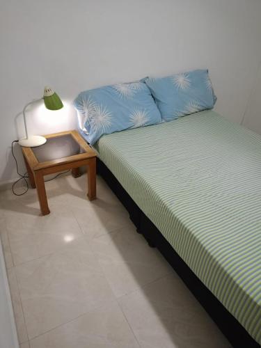 佩雷拉HABITACION CERCA AL AEROPUERTO的床上和桌子上灯