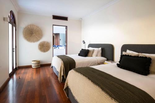 a hotel room with two beds and a mirror at Villa Aman - Tropical Luxury with Infinity Pool in Port Douglas
