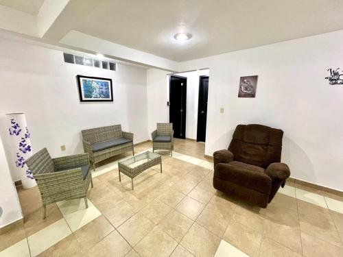 ein Wohnzimmer mit einer Couch und einem Sessel in der Unterkunft Departamento Rosedal 1 in Oaxtepec