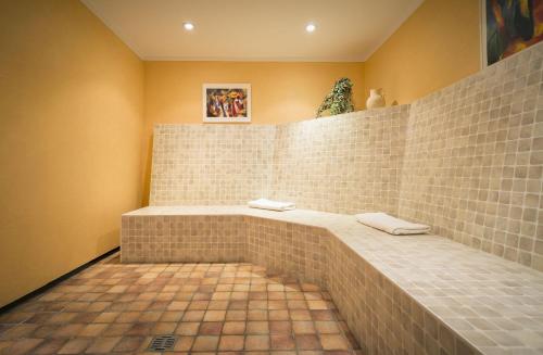 baño con pared de ladrillo y 2 toallas en Hotel Diana, en Bad Bentheim
