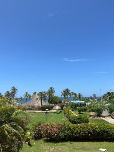 einen Park mit Blumen und Palmen an einem sonnigen Tag in der Unterkunft Terrazas de Guacuco TH in Playa Guacuco