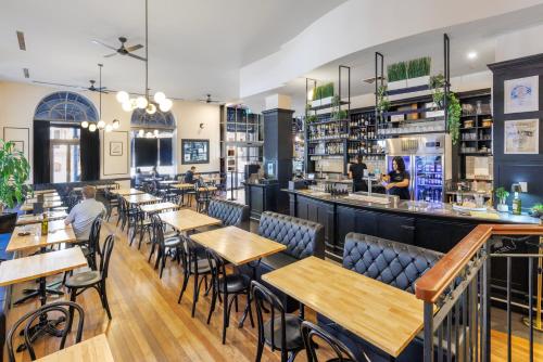 a restaurant with tables and chairs and a bar at The Chancellor on Currie in Adelaide