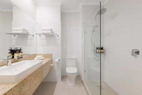 a bathroom with a sink and a toilet and a shower at The Chancellor on Currie in Adelaide