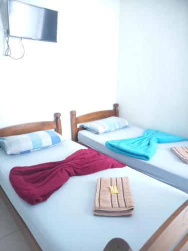 two beds with towels and a napkin on them at Jardim Paraíso in Duque de Caxias