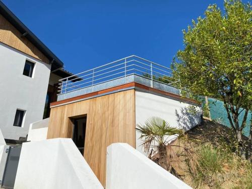 un bâtiment avec une clôture à côté d'un arbre dans l'établissement un petit coin de paradis, à Anglet
