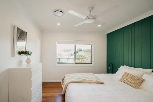 a bedroom with a green accent wall and a bed at Monty's House in Montville