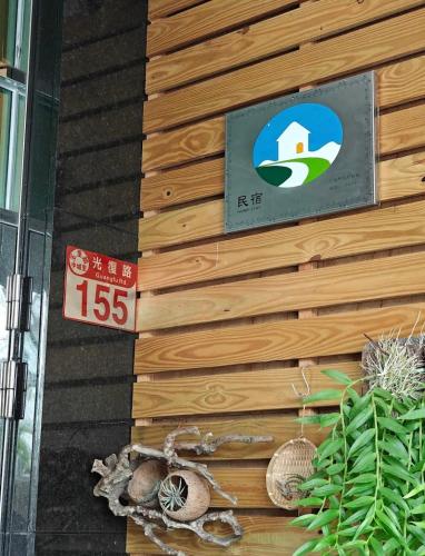 a sign on a wooden wall with a sign on it at JINGTONGYULI BnB 民宿編號2415 in Yuli