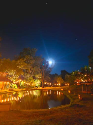 a park at night with a pond and lights at Fazenda Brotas SP in Brotas