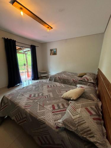 a bedroom with a large bed with two pillows on it at Fazenda Brotas SP in Brotas