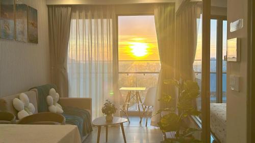 a living room with a view of the sunset at The Song Luxury Vung Tau - Khang Apartment 1 in Vung Tau