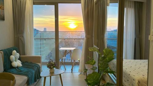 a living room with a view of a sunset at The Song Luxury Vung Tau - Khang Apartment 1 in Vung Tau