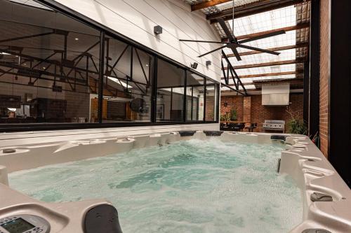 a jacuzzi tub in a room with windows at Newcastle CBD Penthouse, Spa & Entertainment in Wickham