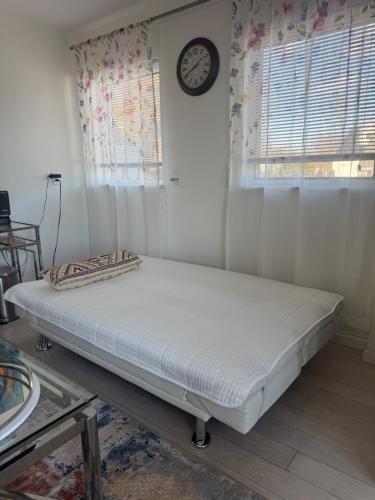 a bed in a room with a clock on the wall at One bedroom with modern kitchen, balcony with water view in Greenwich