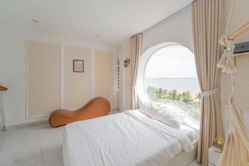 una camera da letto con un letto con una grande finestra di Đào Hoa Homestay a Quy Nhon