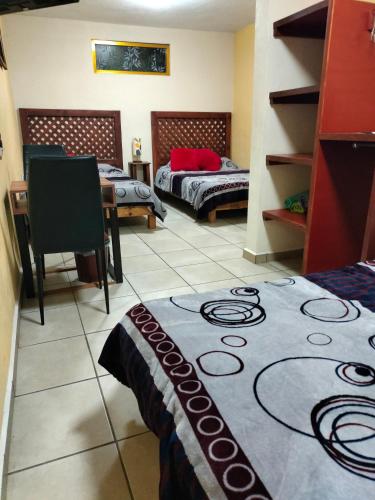 a room with two beds and a table in it at Hospedaje San Francisco.6 personas in Zacatlán