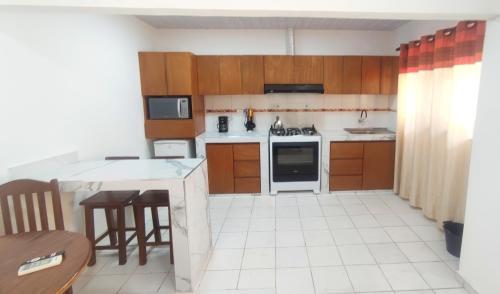 a kitchen with wooden cabinets and a white tile floor at Apartamento completo en Santa Cruz - C in Santa Cruz de la Sierra