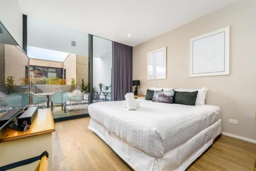 a bedroom with a large bed and a living room at Elegant Apartment in Kingston Foreshore - Hosted by Canstay in Kingston