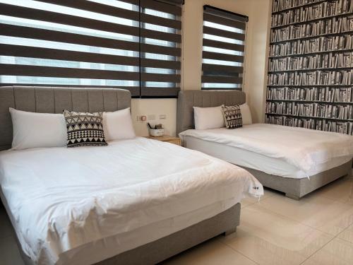 a bedroom with two beds and a large window at Villa Ten in Guilin