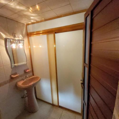 a bathroom with a toilet and a sink next to a door at Departamento San Francisco. 4 personas in Zacatlán