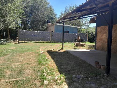 a yard with a fence and a person sitting on a bench at Casa Azul in Villa del Dique
