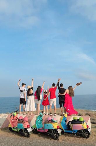a group of people standing next to their motorcycles on the beach at Villa Làng Bè - Đảo Phú Quý in Cù Lao Thu