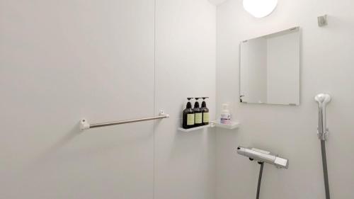 a bathroom with a shower with bottles of wine at 与那国島ホテル むんぶステイ ナンタ浜 in Yonaguni