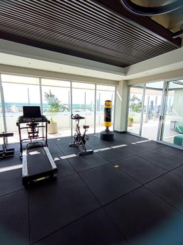 a gym with a treadmill and exercise equipment in a room with windows at Dpto Hestia en Equipetrol in Santa Cruz de la Sierra