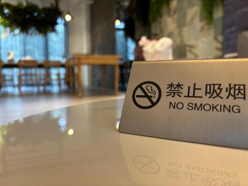 a no smoking sign on a table in a restaurant at Villa Ten - Catch up in Guilin