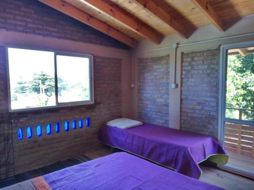 圣罗莎卡拉穆奇塔县Bauha Mini Apart的一间卧室，有两张床和一堵砖墙