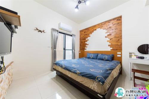 a bedroom with a bed with blue sheets and a window at 卡弧二館 qk民宿4-20人包棟 in Wujie