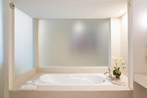 a white bath tub in a bathroom at The Picasso Boutique Serviced Residences Managed by HII in Manila