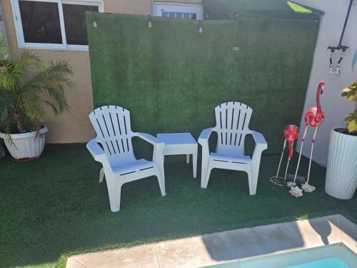 two white chairs and a table on a patio at Jazmin's Apartment in Oranjestad
